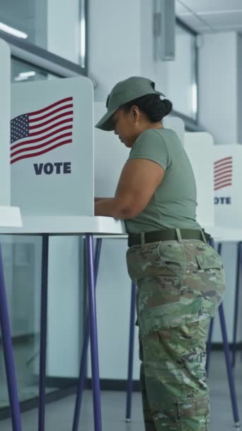 アジア人女性の垂直ショットは 投票所のオフィスで投票ブースに来ます アメリカ合衆国選挙の日 アメリカ合衆国大統領候補の政治的競争 市民の義務の概念と — ストック動画