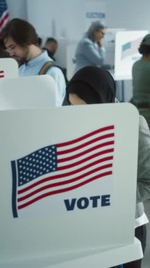 Sandık merkezindeki kabinde tesettürlü Arap kadının dikey çekimi. Birleşik Devletler 'de Ulusal Seçim Günü. ABD başkan adaylarının siyasi ırkları. Vatandaşlık görevi kavramı ve