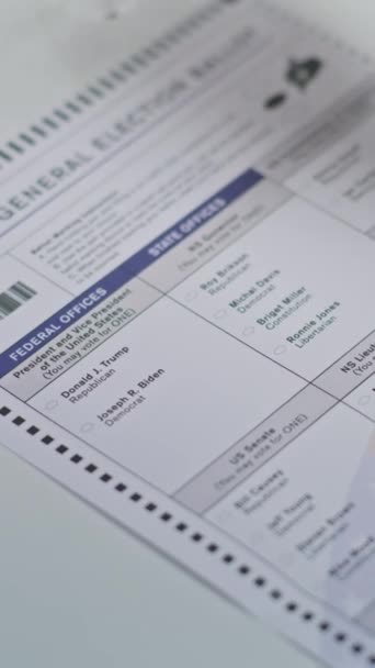 投票ブースに紙の掲示を記入する匿名のアメリカの男性市民の垂直ショット アフリカ系アメリカ人が投票所でジョー バイデンに投票 アメリカ合衆国選挙の日 シビック — ストック動画
