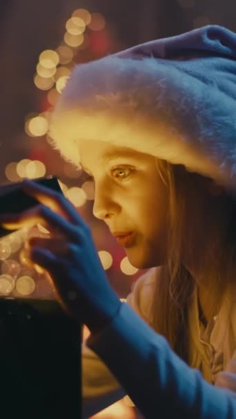 Rozkoszna Dziewczyna Kapeluszu Mikołaja Uśmiechnięta Otwierająca Pudełko Błyszczącym Magicznym Prezentem — Wideo stockowe