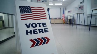 Amerika Birleşik Devletleri 'nde seçim günü. Oylama için Amerikan bayrağı logosunu imzalayın. Seçim merkezinin arka planında oy kullanma kabinleri var. ABD başkan adaylarının siyasi yarışları.
