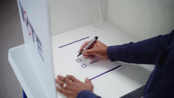 非裔美国人站在投票站的投票站 为总统候选人或政党做出选择和投票 男性选民在选举期间填写纸质公告 公民义务 — 图库视频影像