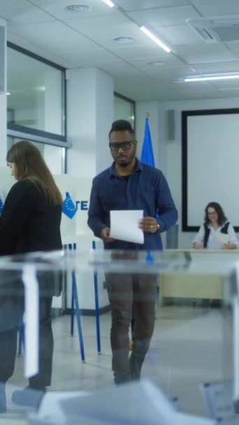 在欧盟选举期间 多族裔选民或欧洲人在投票站投票的垂直镜头 非裔美国男人和女人把布告放在箱子里 欧洲选举日 — 图库视频影像