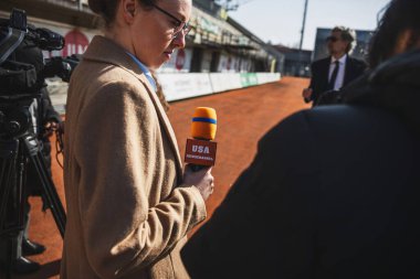 Özel yatırımcı, futbol sahasının yakınında haber muhabirleriyle dolup taşıyor. SEO ya da futbol takımı yöneticisi basın sorularını yanıtlıyor ve maçtan önce röportaj veriyor. Basın konferansında ilham verici bir konuşma..