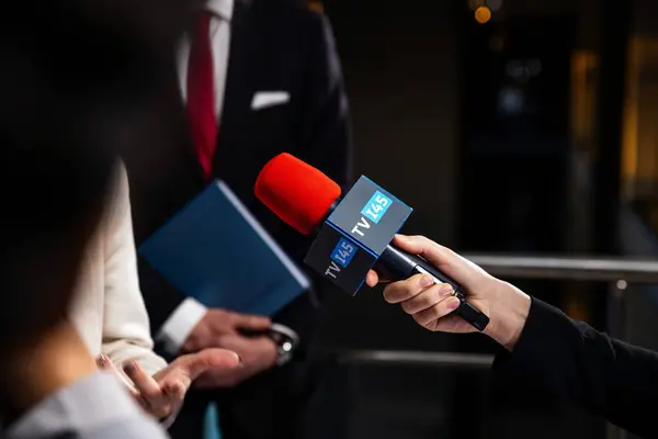 欧盟领事在新闻竞选期间的政治演说 自信的欧洲女政治家回答记者的问题 在欧洲议会大楼接受媒体和电视新闻采访 图库照片