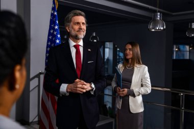 Basın toplantısı sırasında ABD Başkanı. Pozitif Amerikalı politikacı elini sallıyor ve ilham verici bir konuşma sonrasında kameralara poz veriyor veya basın ve televizyon haberleri için gazetecilerle röportaj yapıyor..