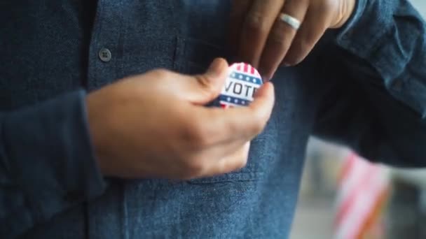 接近匿名的非裔美国男子或美国公民 他们佩戴印有美国国旗标志的徽章 上面有我投的票 投票后在投票站的男性选民 美国的选举日 — 图库视频影像