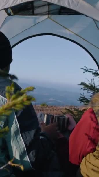 多种族的远足者夫妇坐在山谷的帐篷里 他们聊天 两个旅行者在探险度假期间停下来休息 浪漫的旅游家庭热身欣赏风景 — 图库视频影像