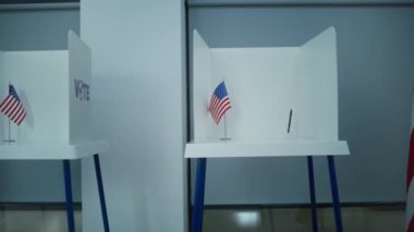 Amerikan bayrağı logosu olan oy kullanma kabinlerinin hafif oy kullanma merkezindeki çekimleri. Amerika Birleşik Devletleri 'nde Ulusal Seçim Günü. ABD başkan adaylarının siyasi ırkları. Demokrasi.