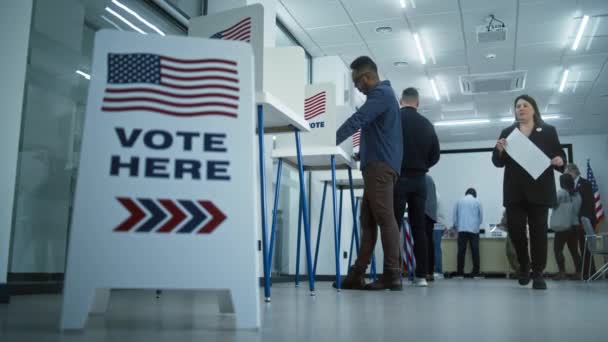 在这里投票在地板上签名 不同的美国公民在投票站的投票站投票 美国的全国选举日 美国总统候选人的政治竞争 公民义务 — 图库视频影像