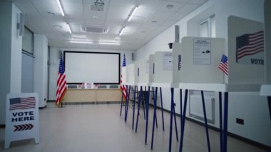 Oy sandığı ofisinde Amerikan bayrağı logosu olan kabinler. Işıklar kapanıyor. Amerika Birleşik Devletleri 'ndeki Ulusal Seçim Günü' nün sonu. ABD başkan adaylarının siyasi yarışları.
