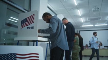 Modern oy kullanma merkezindeki kabinde Afrikalı Amerikalı bir adam oy veriyor. Birleşik Devletler 'de Ulusal Seçim Günü. ABD başkan adaylarının siyasi ırkları. Vatanseverlik ve vatandaşlık görevi kavramı.