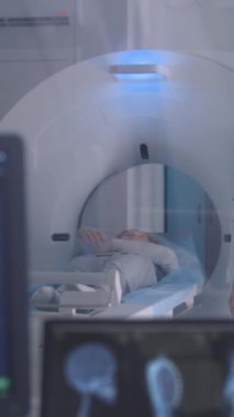 Profesyonel kadın doktor MRI veya CT 'yi veya PET taramasını hasta işlemleri ile kontrol eder. Kamera görüntüyü görüntülü beyin taramalarıyla değiştiriyor ve kontrol odasında sonuç veriyor. Dikey çekim