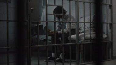 Afro-Amerikalı genç mahkum hapishane hücresinde yatarken demir kaseden iğrenç hapishane yemekleri yiyor. Genç suçlu, mahkum hapiste suçtan hapis cezasına çarptırıldı. Gençlik Gözaltı Merkezi.