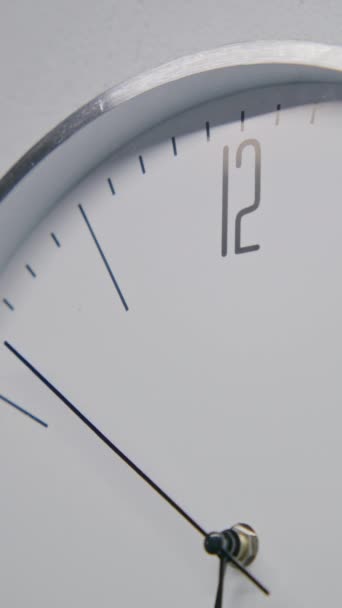 用现代设计在办公室里静止不动地拍摄行走的墙上时钟 带有金属框架的白色手表挂在墙上 显示时间 带有运行时间指针的严格设计时钟 时间间隔 靠近点 — 图库视频影像