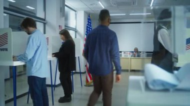 Çok ırklı seçmenler ya da Amerikan halkı oy kullanma merkezindeki kabinlerde oy kullanıyor. Asyalı kadın ve Afro-Amerikan kadın ordusu ilan kutusuna koydu. Birleşik Devletler 'de Ulusal Seçim Günü. Yurttaşlık görevi.
