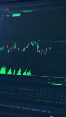 Profesyonel ticaret uygulamasının görüntülü arayüzü olan bilgisayar monitörü. Japon şamdanı animasyonlu borsa grafiği. Monitördeki hisse senetlerinin ekonomik grafikleri yükselip alçalıyor. Dikey