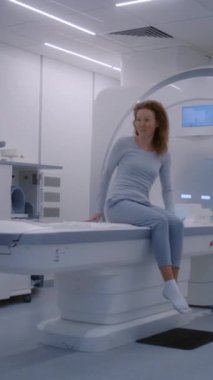 Bayan doktor, radyoloji uzmanı kadın hasta için MRI veya CT tarama makinesini kontrol edip çalıştırıyor. Gelişmiş tıp teknolojileri ile modern klinikte kanser önleme kontrolünden geçen beyaz kadın..