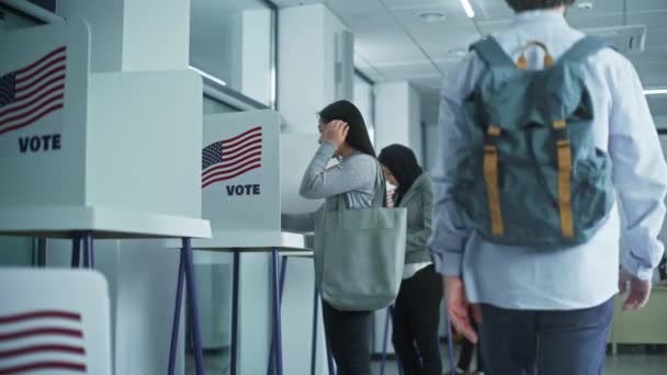 アジアの女性は投票所のオフィスで投票ブースに来ます アメリカ合衆国選挙の日 アメリカ合衆国大統領候補の政治的競争 市民の義務と愛国心の概念 ドリー ショット — ストック動画
