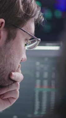 Finansal analistler, iş adamları gerçek zamanlı hisse senedi ve borsa grafiklerini bilgisayarda izleyip banka ofisinde çalışıyorlar. Arka planda büyük dijital ekran. Kripto para ticareti ve yatırım. Dikey