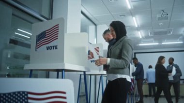 Arap kadın Amerikan vatandaşı oy kullanma merkezindeki kabinde oy kullanıyor. Birleşik Devletler 'de Ulusal Seçim Günü. ABD başkan adaylarının siyasi ırkları. Vatanseverlik ve vatandaşlık görevi kavramı.