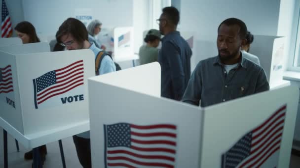 アフリカ系アメリカ人男性が投票所でブースに投票する アメリカ合衆国の国民選挙の日 アメリカ合衆国大統領候補の政治的競争 市民の義務 スローモーション ドリー ショット — ストック動画