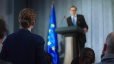 Medyanın kadın temsilcisi basın toplantısında performansını sergileyen Avrupalı politikacıya soru soruyor. AB konsolosluğunun bir duyuru yaptığından, kampanya konuşması yaptığından ve röportaj verdiğinden emin. Seçim günü..