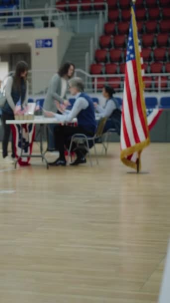在这里投票在地板上签名 多样化的美国公民来到投票站投票 美国的全国选举日 美国总统候选人的政治竞争 公民义务 垂直射击 — 图库视频影像