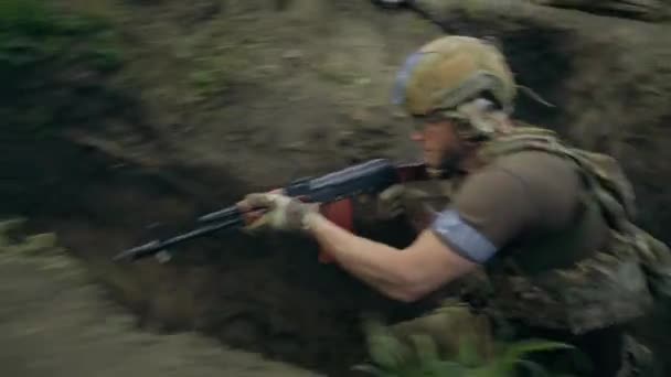 攻击敌方阵地 两名身着迷彩服 头戴钢盔的乌克兰男性士兵或战士穿过战壕 用自动步枪射击 战争或军事冲突 国土防卫 — 图库视频影像