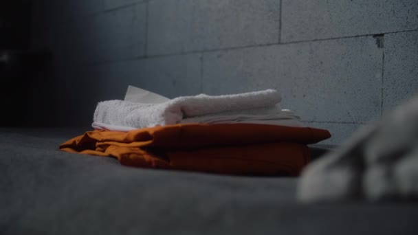 关闭囚犯 将橙色监狱制服和浴室配件放在床上 犯罪的罪犯或囚犯在狱中服刑 拘留中心或教养所 司法系统 — 图库视频影像