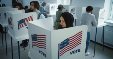 Sandık merkezindeki kabinde tesettürlü Arap kadın oy kullanıyor. Birleşik Devletler 'de Ulusal Seçim Günü. ABD başkan adaylarının siyasi ırkları. Vatandaşlık görevi ve vatanseverlik kavramı. Dolly vurdu..