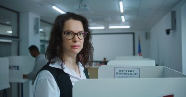 Amerikan kadınlarının oy verme kabinindeki başkan adayı için oy verirken yakın plan çekimleri, sonra gülümseyip kameraya bakarken. ABD 'de Ulusal Seçim Günü' nde ABD vatandaşı.