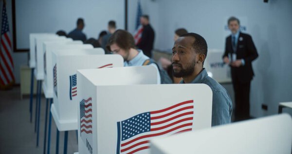 Гражданин афроамериканцев приходит голосовать в кабинке в избирательном участке. Национальный день выборов в США. Политические гонки кандидатов в президенты США. Концепция гражданского долга и патриотизма.
