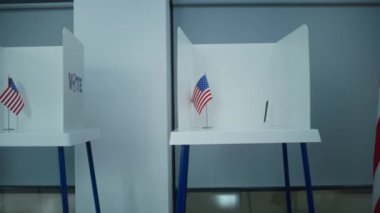 Amerikan bayrağı logosu olan oy kullanma kabinlerinin hafif oy kullanma merkezindeki çekimleri. Amerika Birleşik Devletleri 'nde Ulusal Seçim Günü. ABD başkan adaylarının siyasi ırkları. Demokrasi.