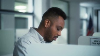 Afrika kökenli Amerikalı erkek seçmen oy verme merkezindeki oy verme kabininde hangi başkan adayına oy vereceğini seçer. Amerika Birleşik Devletleri 'ndeki Ulusal Seçim Günü' nde Amerikan vatandaşı. Yurttaşlık görevi.