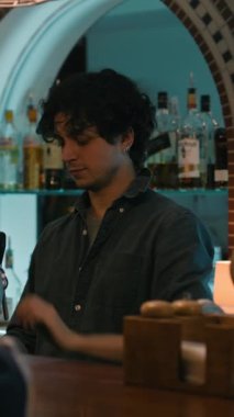 Genç barmenin dikey pozu bardaklara bira doldurup ziyaretçilere dağıtıyor. Barmen emirleri alır, bar tezgahında oturan insanlarla konuşur, geceleri şık bir barda çalışır. Konsept