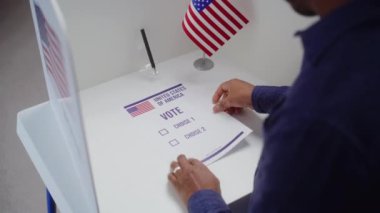 Afro-Amerikalı erkek seçmen oy kullanma yerine gelir, seçim yapar ve kağıt oy pusulalarını doldurur. Amerika Birleşik Devletleri 'ndeki Ulusal Seçim Günü' nde Amerikan vatandaşı. Yurttaşlık görevi.