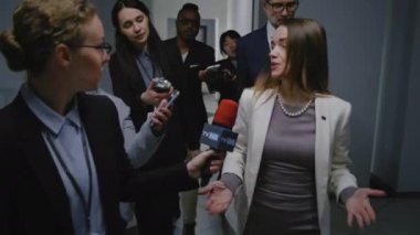 Olumlu kadın AB konsolosu basın sorularını yanıtlıyor ve hükümet binası koridorunda yürüyen medya için röportaj veriyor. Avrupa Birliği Temsilcisi TV gazetecileriyle çevrili. Basın