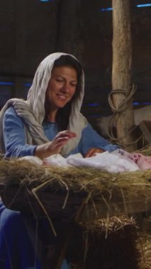 Pan, Bakire Meryem ve Yusuf 'un Noel günü Bethlehem' deki handa bebek İsa ile yemlikte konuştuklarını gördü. Dikey çekim.