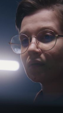 Modern stüdyoda bilgisayar ekranına bakan kadın bilgisayar kullanıcısının dikey görüntüsü. Genç kız video renk düzeltmesi yapıyor, fotoğraf düzenliyor, tasarım geliştiriyor, programlama kodu yazıyor. Serbest ve uzak çalışma