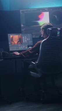 Kadın film editörü ya da renkçi modern stüdyoda bilgisayar üzerinden renk değerlendirmesi yapıyor. Duvarda RGB renk düzeltme çubuğu ve program arayüzü olan büyük monitörler. Video prodüksiyonu. El bilgisayarı.