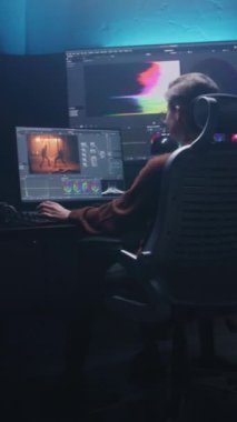 Kadın editör stüdyoda renk derecelendirme kontrol paneli ve profesyonel video düzenleme yazılımı kullanarak bilgisayar üzerinde çalışıyor. Yapım sonrası film için renk düzeltmesi. RGB grafikli ve seviyeli büyük ekranlar.