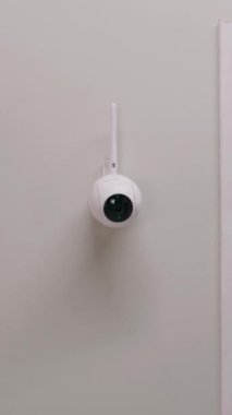 Modern apartmanın duvarına yerleştirilmiş güvenlik kamerasının dikey görüntüsü. Mikrofon ve hareket sensörlü CCTV kamerası. İzleme sistemi, izleme, güvenlik ve kişisel mahremiyet kavramı.