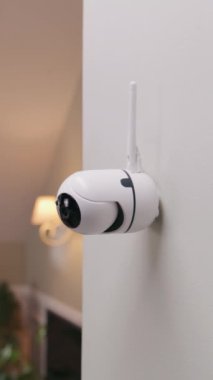 Modern apartmanın duvarına yerleştirilmiş güvenlik kamerasının yakın çekim görüntüsü. Mikrofon ve yeşil göstergeli CCTV kamerası. İzleme sistemi, gözetleme ve kişisel mahremiyet kavramı. Dikey çekim