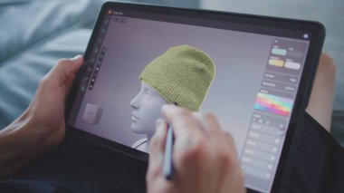 Elinde tablet ve dijital kalemle odaklanmış bir genç odada oturuyor ve 3D modeller çiziyor. Çocuk 3 boyutlu modelleme programı kullanarak yeni oyun karakterleri ve animasyonlar yaratıyor. Oyun tasarımı ve geliştirmesi. Kapat..