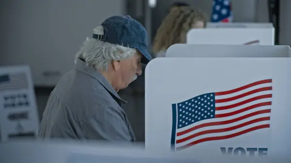 Stock image Multicultural American citizens come to voting booth in polling station office. National Election Day in the United States. Political races of presidential candidates. Civic duty, patriotism concept.