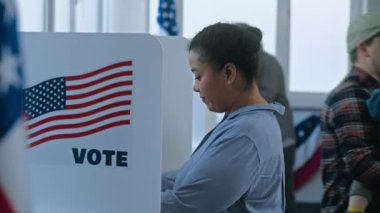 Çok kültürlü Amerikan vatandaşları oy kullanma merkezindeki oy kullanma kabinine geliyorlar. Birleşik Devletler 'de Ulusal Seçim Günü. Başkan adaylarının politik ırkları. Vatandaşlık görevi, vatanseverlik kavramı.