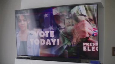 Siyasi kampanyası ya da ABD başkanlık seçimleriyle ilgili reklamları olan büyük bir televizyon ekranı. Çok ırklı seçmenlerden canlı yayında oy kullanma çağrısı. Ulusal Seçim Günü. Vatandaşlık görevi ve vatanseverlik.