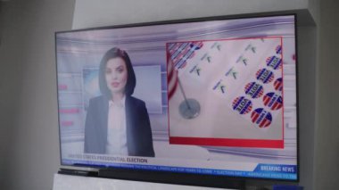 Oturma odasındaki duvarda, Amerika Birleşik Devletleri 'ndeki seçimlerle ilgili televizyon haberleri olan büyük bir televizyon var. ABD 'de ulusal seçim günü. Televizyon canlı yayında. Vatandaşlık görevi ve vatanseverlik. Kapat..