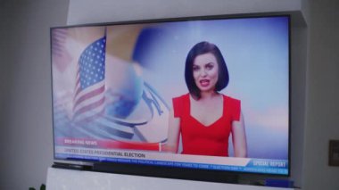Amerika Birleşik Devletleri 'ndeki seçimlerle ilgili haberleri içeren büyük düz ekran TV monitörünün yakın çekimini yapın. Kadın haber spikeri, halkı seçim günü oy vermeye davet ediyor. TV canlı yayını.